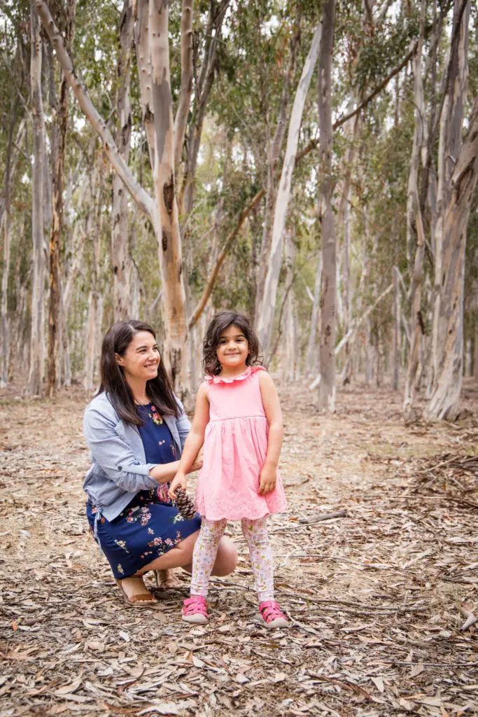 Woman preparing her daughter for a shoot outdoors