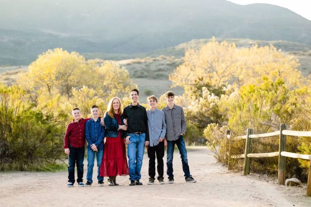 A family of six taking outdoor family photos near a park