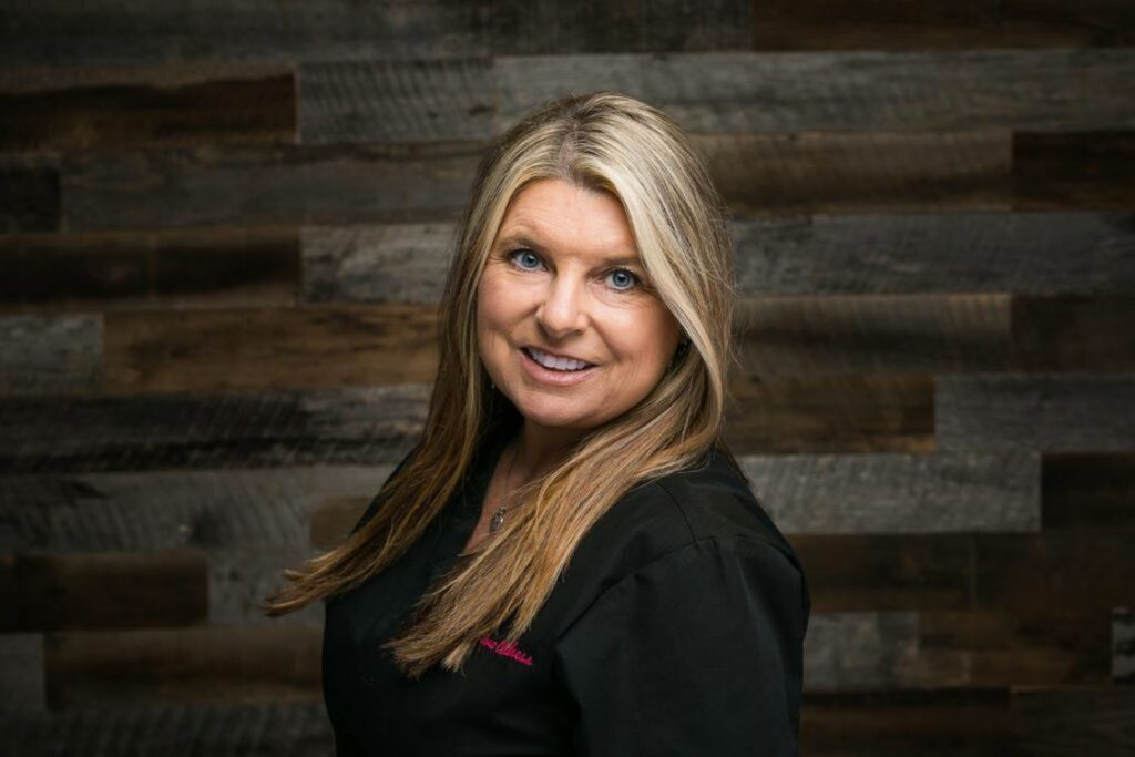 Woman wearing black medical scrubs while posing in a studio for her headshot