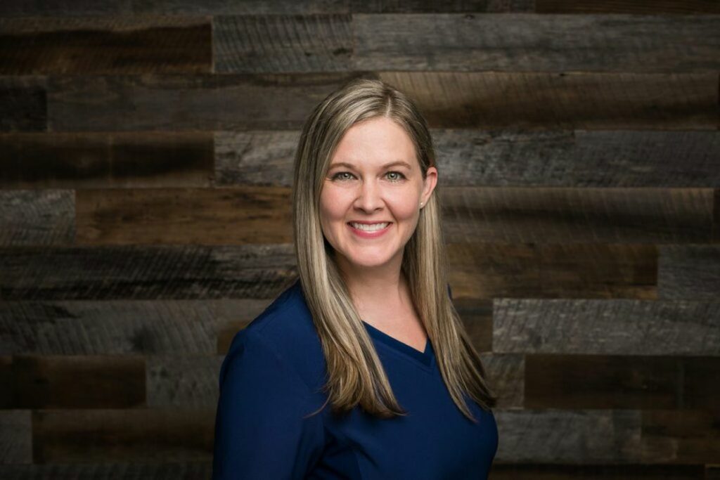 Woman wearing a blue shirt in a studio while posing for her headshot