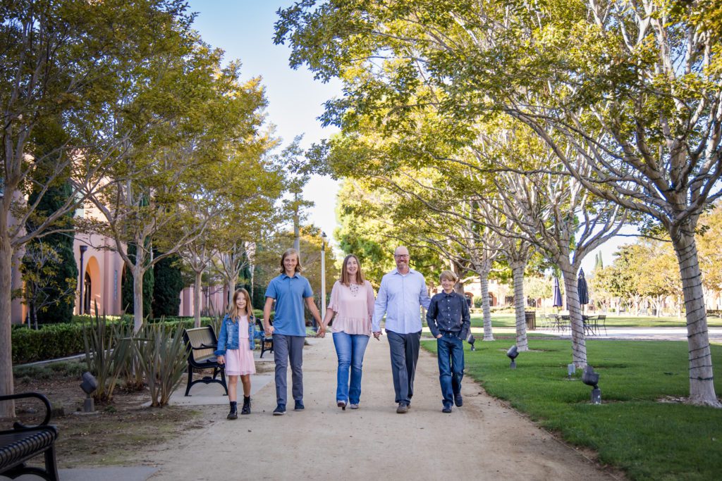 Family of five posing for a family photoshoot in a park at Liberty Station