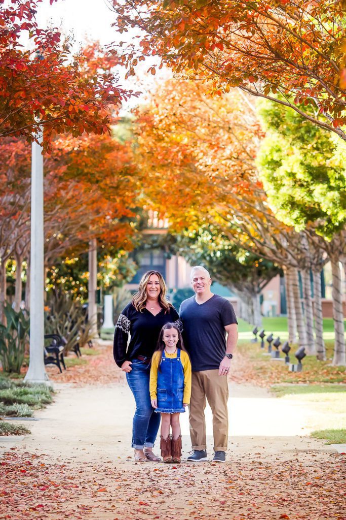 Couple with their little girl posing at a park for a family shoot