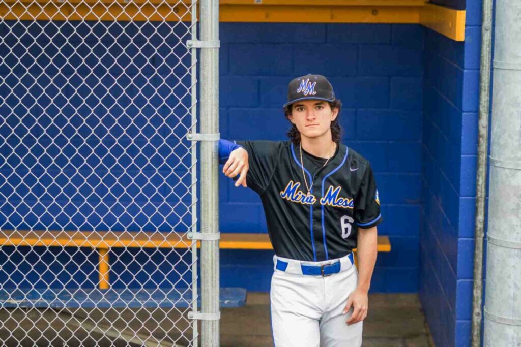 A senior student wearing a football uniform and posing for his portrait