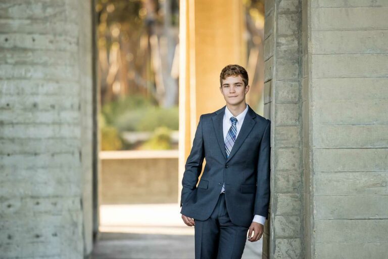 A man with formal suit posing outside for his senior photograph