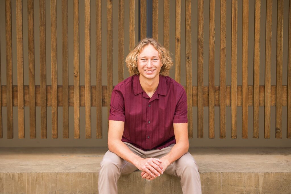Young man sitting on a concrete step, smiling